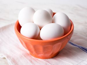 White eggs in an orange bowl.