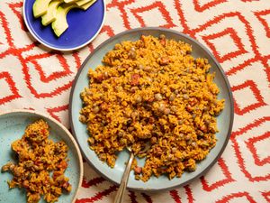 Overhead view of arroz con gandules on a red patterned background