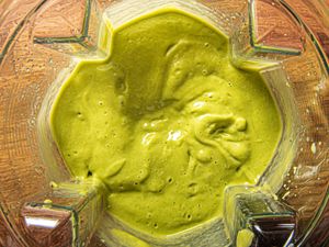 Blended avocado smoothie inside a blender container