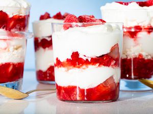 Eton mess desserts in glasses, layered with cream and strawberries