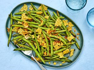 A plate of air-fried green beans with shattered frico and shallots