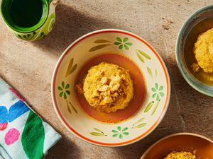 Bowl of Mofongo from above in a bone colored dish with flowers on it, and edges of other bowls of mofongo on the bottom rightside.