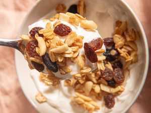 Overhead view a of spoon lifting up granola and yogurt