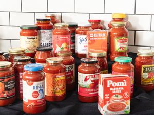 various jars of marinara against white tiles and a black surface
