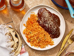 Plate with mole negro and rice served with tortillas on the side