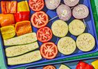 Assorted vegetables sliced and seasoned, arranged on a tray for cooking