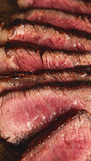 Slices of cooked steak arranged on a wooden surface