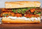 A closeup of a crispy zucchini sandwich with bread ricotta and pesto layers