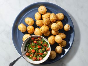 Fried papas criollas on a blue ceramic plate with ajÃ.