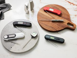 several kitchen thermometers on a marble countertop