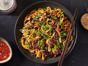 Stir-fried lo mein noodles with pork and vegetables served on a platter