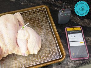 the probe stuck into a raw, butterflied chicken