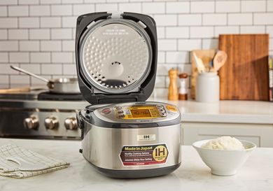 The Zojirushi rice cooker with its lid open.