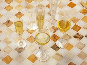 a variety of champagne glasses on a marble tile surface