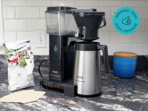 the technivorm moccamaster on a countertop with a bag of coffee and some filters